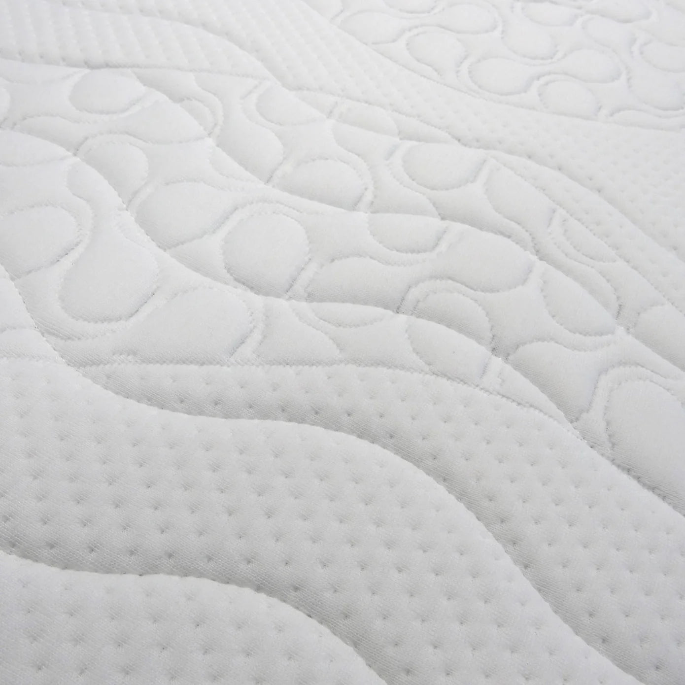 Close-up of a textured white mattress cover with wavy pattern