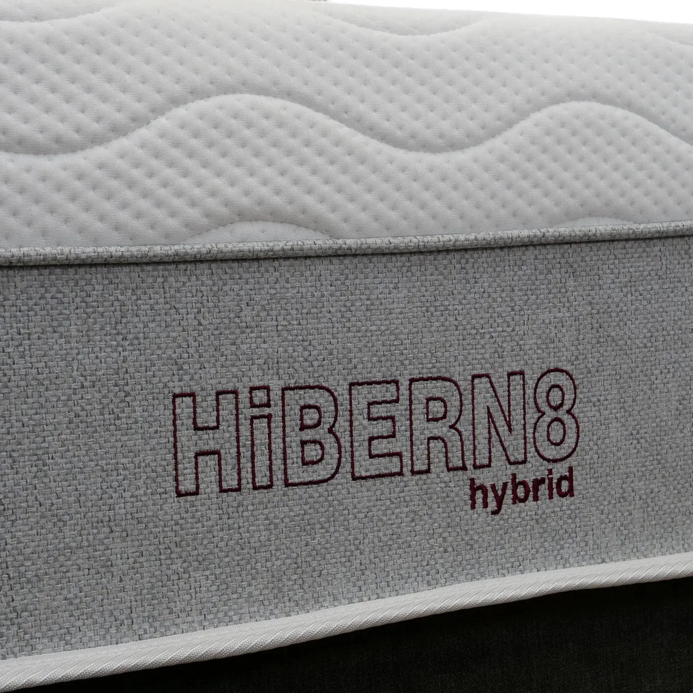 Gray mattress with 'Hibern8 hybrid' branding on a black background