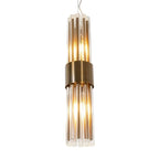 A modern chandelier pendant light with a brushed brass band and clear glass rods, glowing with warm light against a solid gray background.