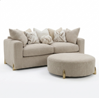 A light beige upholstered sofa with matching accent pillows and a round matching ottoman, shown on a clean white studio background.