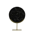 Round black marble table with gold stand on a white background