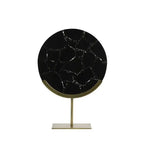 Round black marble table with gold stand on a white background