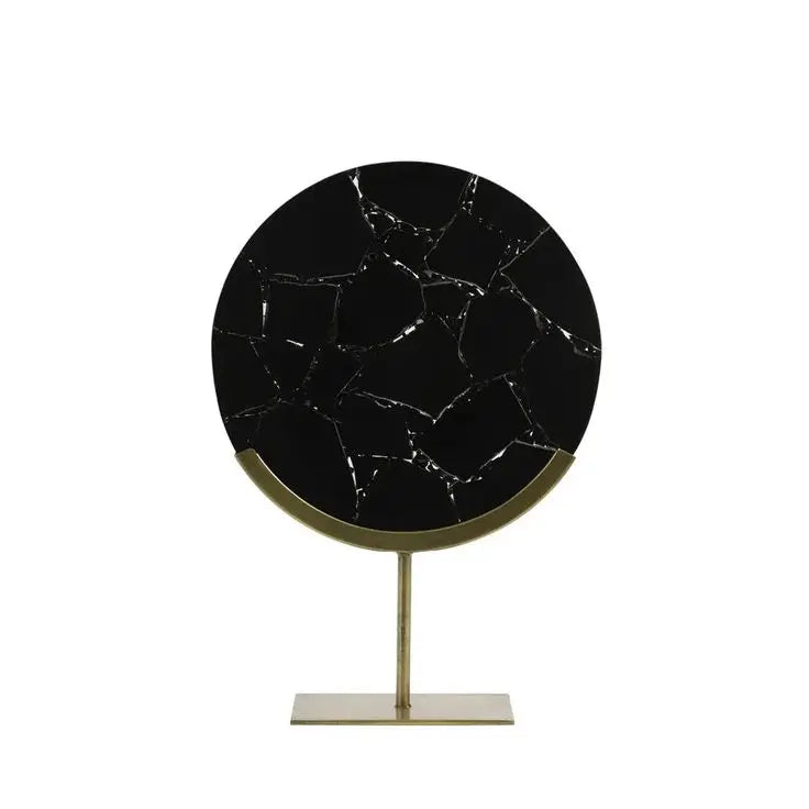 Round black marble table with gold stand on a white background