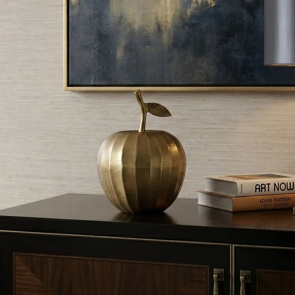 Modern living room with a decorative apple, lamp, and books on a console table.