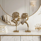 Decorative setup with sculptures, books, and a vase on a marble surface.